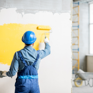 A professional painter with a roller in hand, applying paint to a wall, representing expert outdoor and indoor paint services for residential and commercial properties. Keywords: Painter, painting services, residential painting, commercial painting, interior painting, exterior painting, professional painter, home improvement, property renovation, skilled craftsmanship.